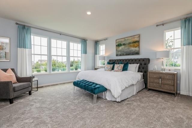 bedroom with light carpet and multiple windows