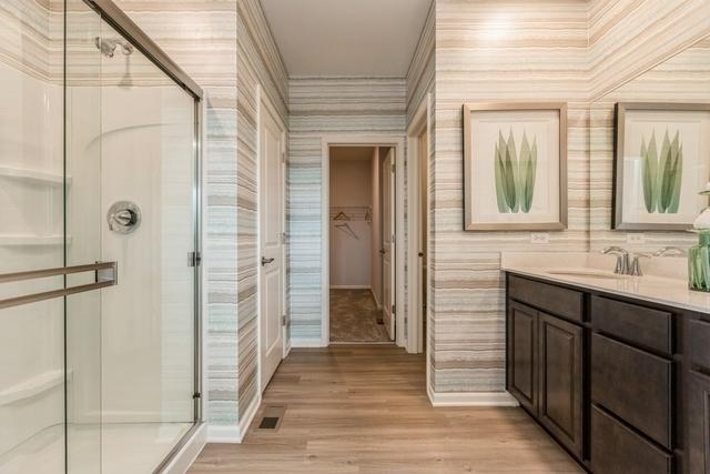 bathroom featuring an enclosed shower, vanity, and wood-type flooring