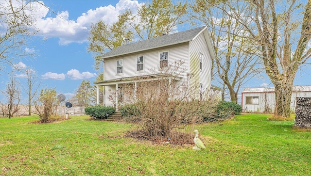 rear view of property featuring a yard