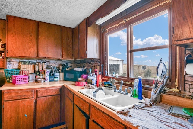 kitchen with backsplash, sink, and a textured ceiling