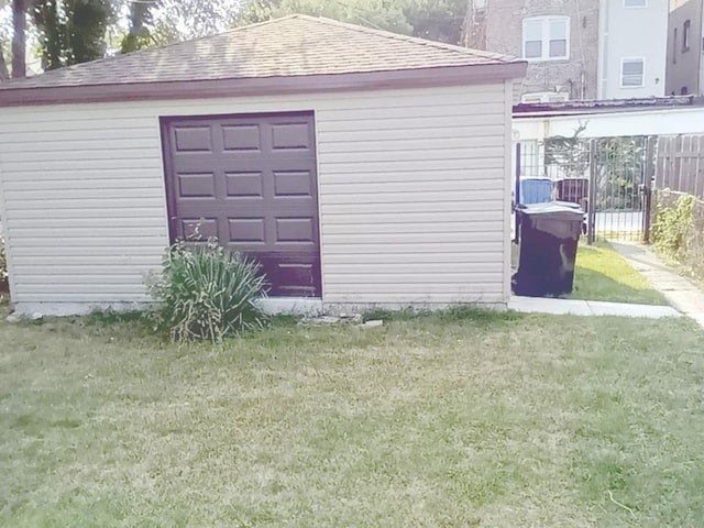 view of outdoor structure with a lawn and a garage