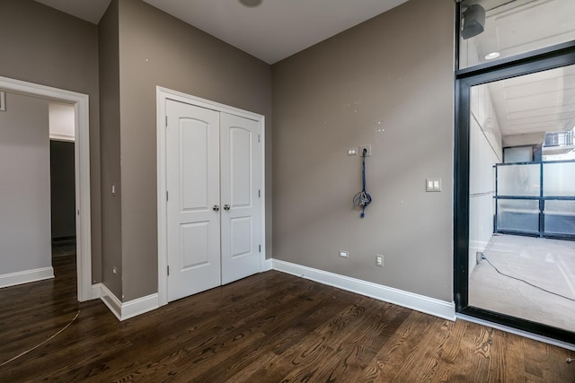 unfurnished bedroom featuring a closet and dark hardwood / wood-style floors