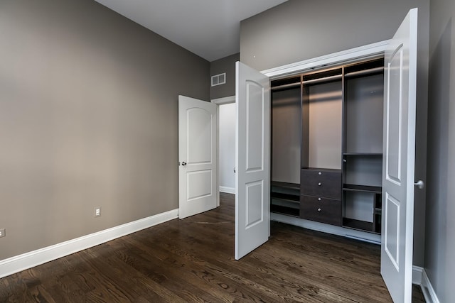 unfurnished bedroom featuring a closet and dark hardwood / wood-style flooring