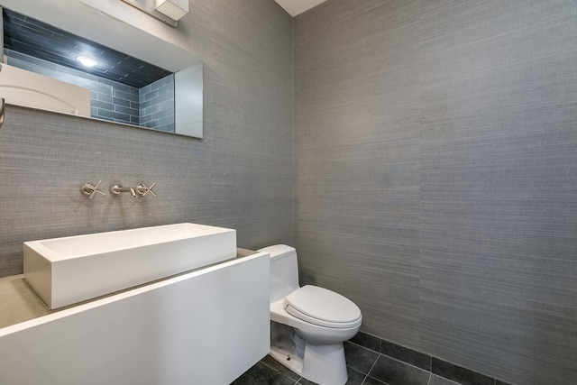 bathroom featuring tile patterned flooring, toilet, and tile walls