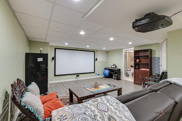 home theater with a paneled ceiling and hardwood / wood-style flooring