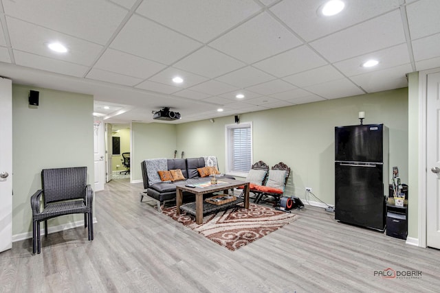 living room with a paneled ceiling and light wood-type flooring