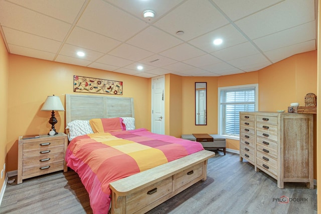 bedroom with hardwood / wood-style flooring and a drop ceiling