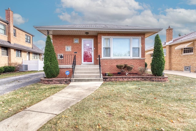 bungalow with central AC unit and a front lawn