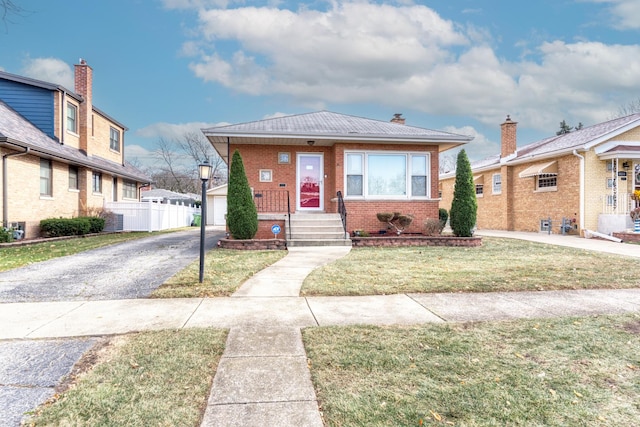 bungalow-style home featuring an outbuilding, a garage, and a front yard