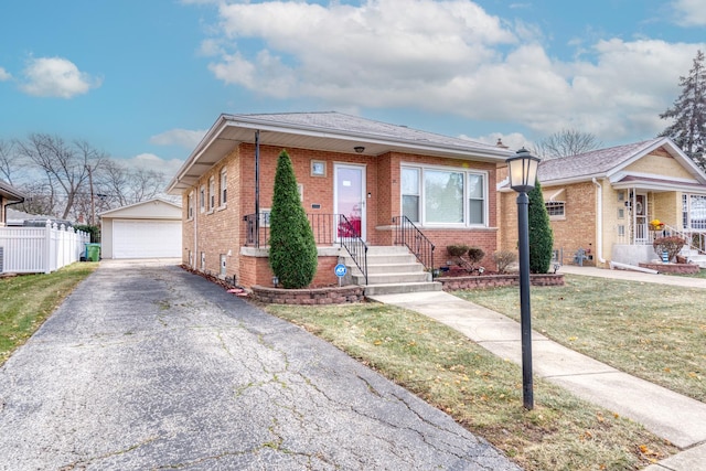 view of front of home with an outbuilding, a front yard, and a garage