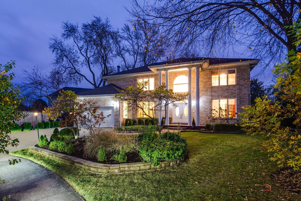 view of front of property featuring a garage and a front lawn