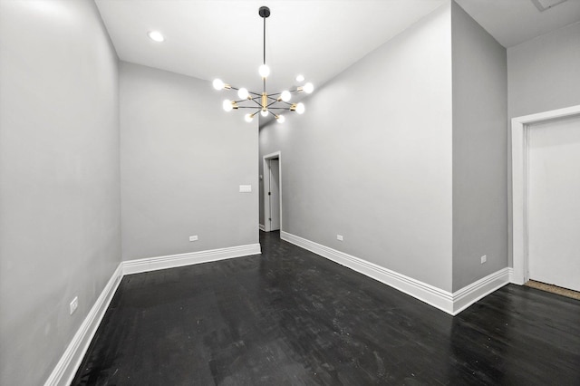 unfurnished dining area with dark wood-type flooring and a chandelier