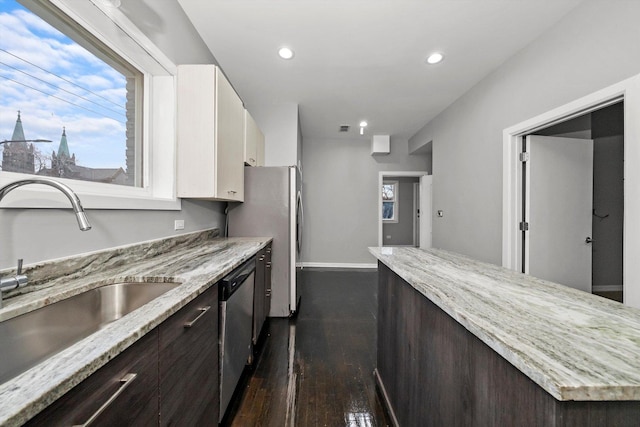 kitchen featuring white cabinets, sink, dark hardwood / wood-style floors, light stone countertops, and stainless steel appliances