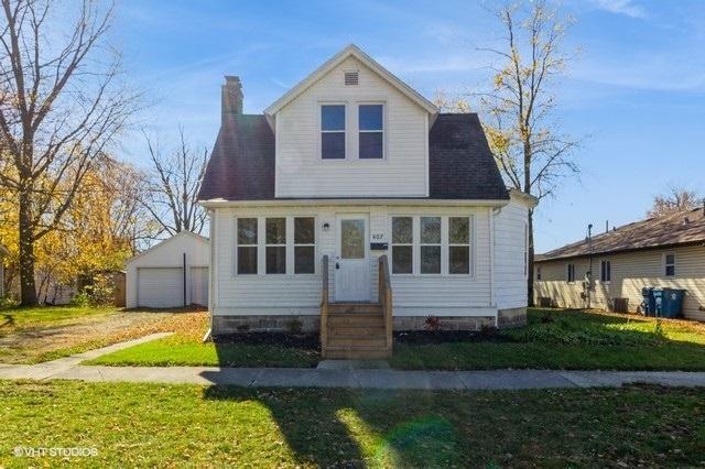 view of front of house with a garage, an outdoor structure, and a front yard