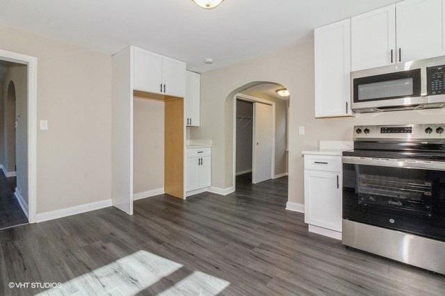 kitchen featuring white cabinets, stainless steel appliances, and dark hardwood / wood-style floors