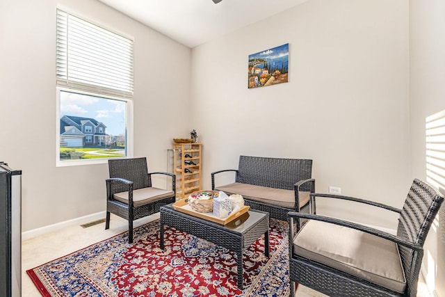 sitting room featuring baseboards, plenty of natural light, and carpet