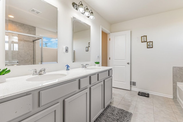 bathroom featuring a shower stall, tile patterned floors, a sink, and visible vents