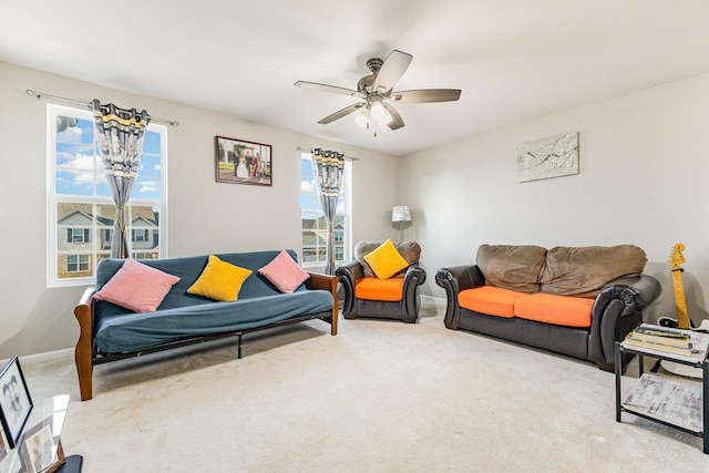 carpeted living room featuring ceiling fan and baseboards