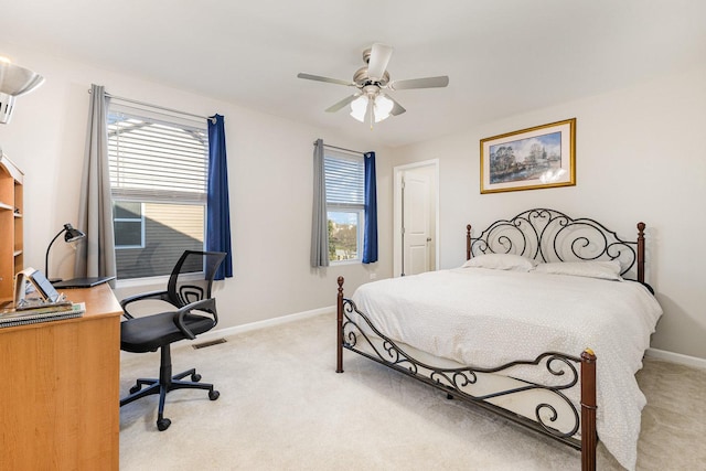 bedroom featuring visible vents, light colored carpet, baseboards, and a ceiling fan