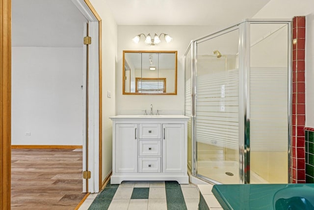 bathroom with hardwood / wood-style floors, vanity, and a shower with door