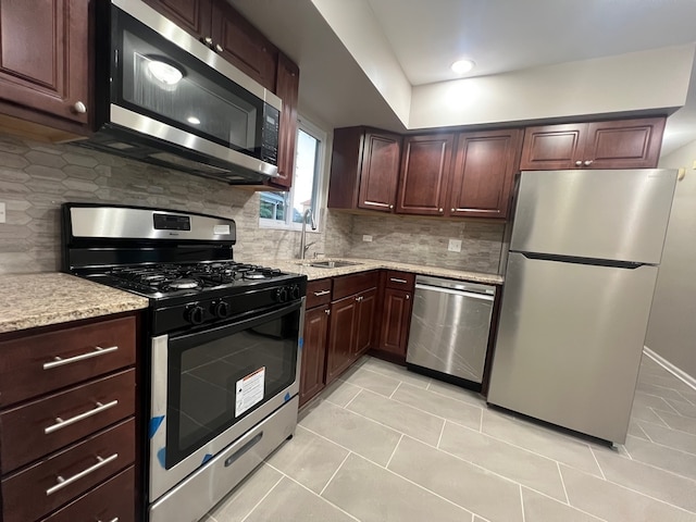 kitchen featuring tasteful backsplash, sink, light tile patterned flooring, and appliances with stainless steel finishes