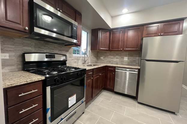 kitchen with sink, stainless steel appliances, light stone counters, decorative backsplash, and light tile patterned floors