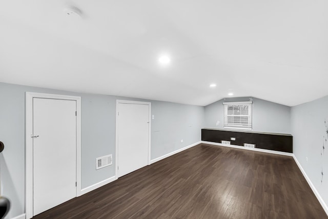 additional living space featuring dark hardwood / wood-style flooring and vaulted ceiling