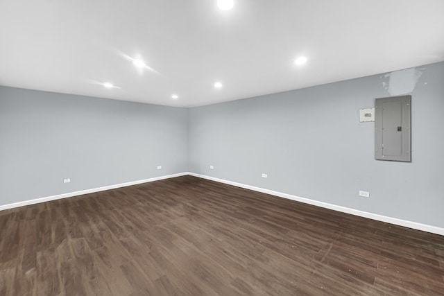 empty room featuring electric panel and dark hardwood / wood-style flooring