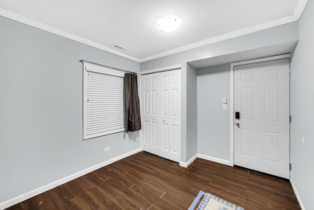 unfurnished bedroom featuring dark hardwood / wood-style floors, ornamental molding, and a closet