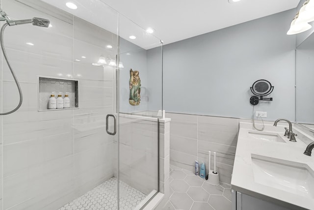 bathroom featuring tile patterned floors, vanity, walk in shower, and tile walls