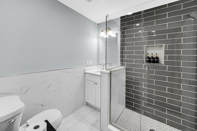 bathroom featuring vanity, a shower with door, tile walls, a chandelier, and toilet