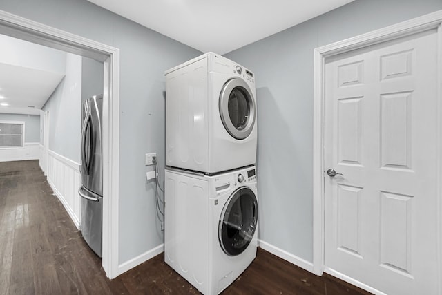 laundry room featuring dark hardwood / wood-style flooring and stacked washing maching and dryer