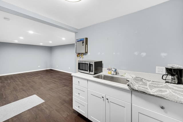 kitchen with dark hardwood / wood-style flooring, white cabinetry, and sink