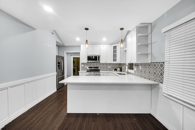 kitchen featuring kitchen peninsula, dark hardwood / wood-style flooring, stainless steel appliances, decorative light fixtures, and white cabinets