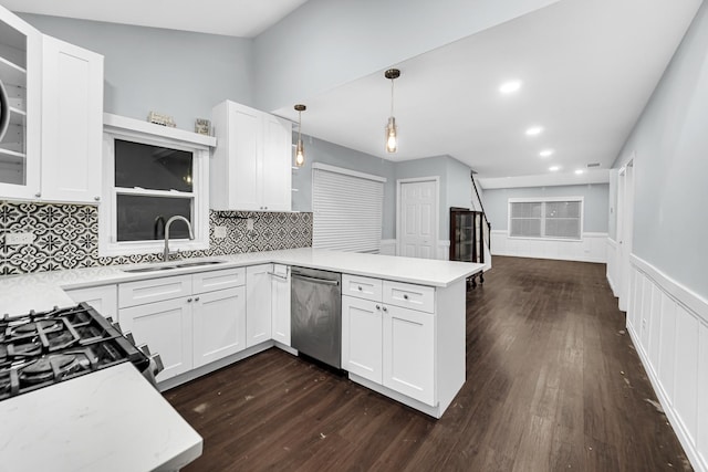 kitchen featuring pendant lighting, dishwasher, kitchen peninsula, sink, and white cabinetry