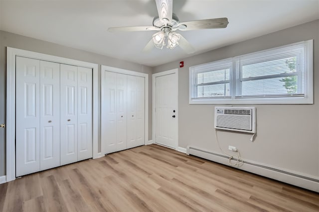 unfurnished bedroom with ceiling fan, light hardwood / wood-style floors, multiple windows, and a baseboard heating unit