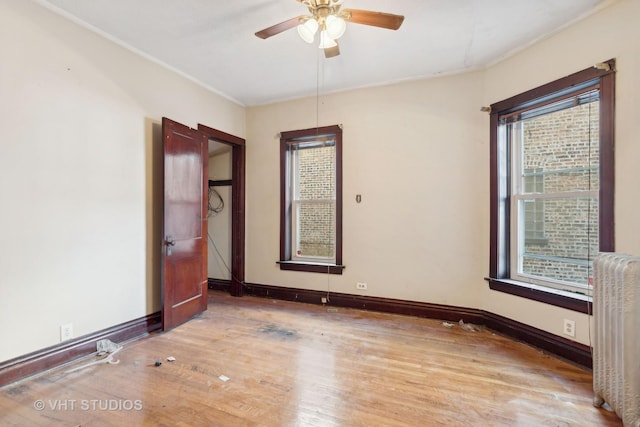 spare room with radiator, ceiling fan, and hardwood / wood-style floors