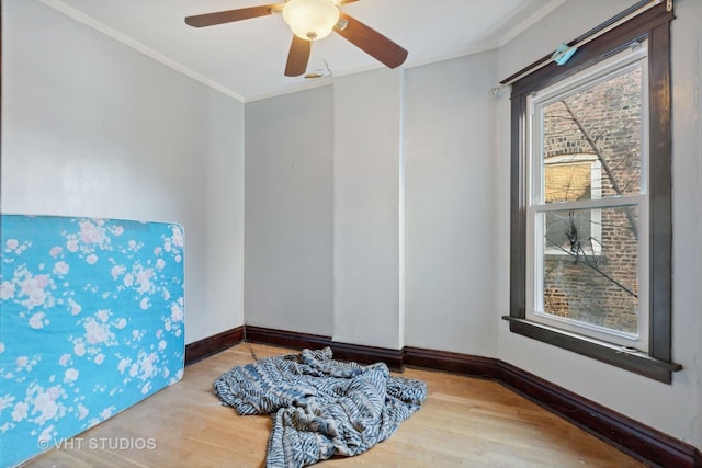 unfurnished room featuring hardwood / wood-style floors, ceiling fan, a healthy amount of sunlight, and crown molding