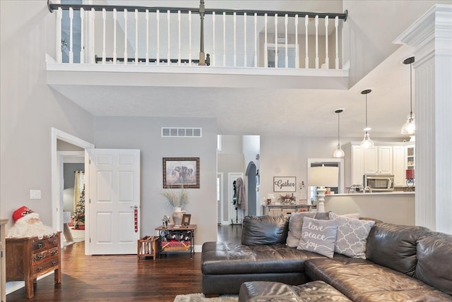 living room with a high ceiling and dark hardwood / wood-style floors