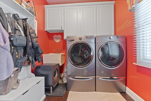 laundry room with dark hardwood / wood-style flooring, cabinets, separate washer and dryer, and sink