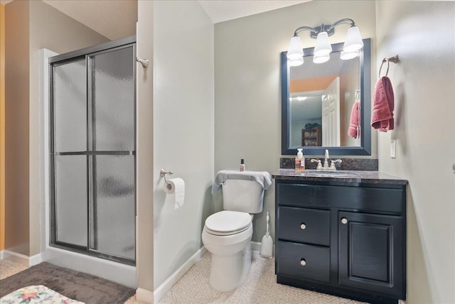 bathroom featuring tile patterned flooring, toilet, vanity, and walk in shower