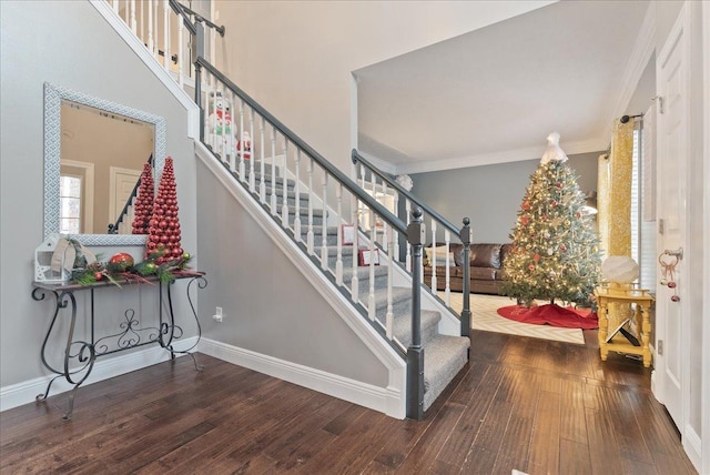 stairs with hardwood / wood-style floors and ornamental molding