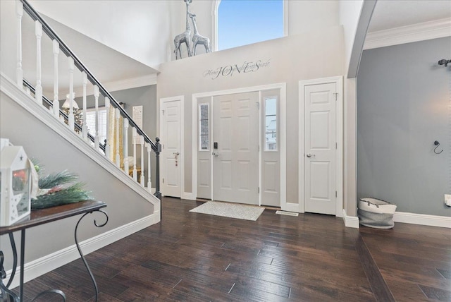 entrance foyer featuring crown molding, a towering ceiling, and dark hardwood / wood-style floors