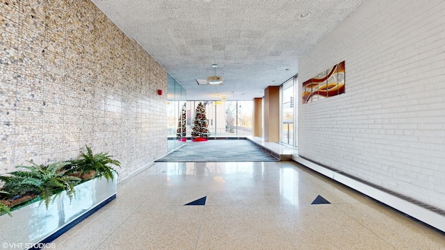 hall featuring brick wall and a baseboard heating unit