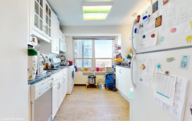 kitchen featuring white appliances, white cabinetry, and light hardwood / wood-style flooring