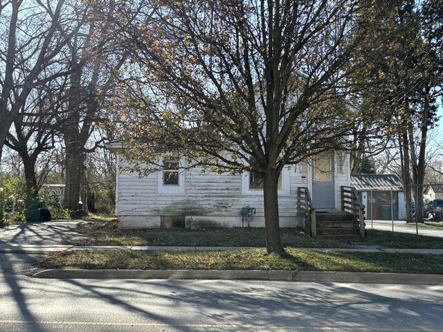 view of property hidden behind natural elements with a front yard