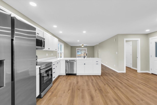 kitchen featuring white cabinetry, appliances with stainless steel finishes, sink, and kitchen peninsula