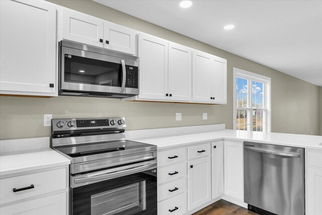 kitchen featuring white cabinetry, appliances with stainless steel finishes, and dark wood-type flooring