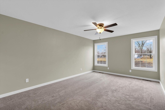 spare room with ceiling fan and carpet