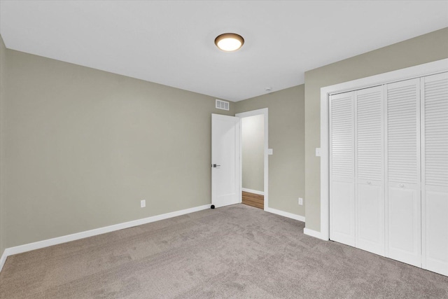 unfurnished bedroom featuring light colored carpet and a closet